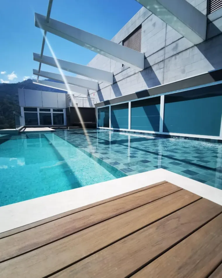Piscina en la azotea de Condominios 325, con deck de madera y las montañas al fondo